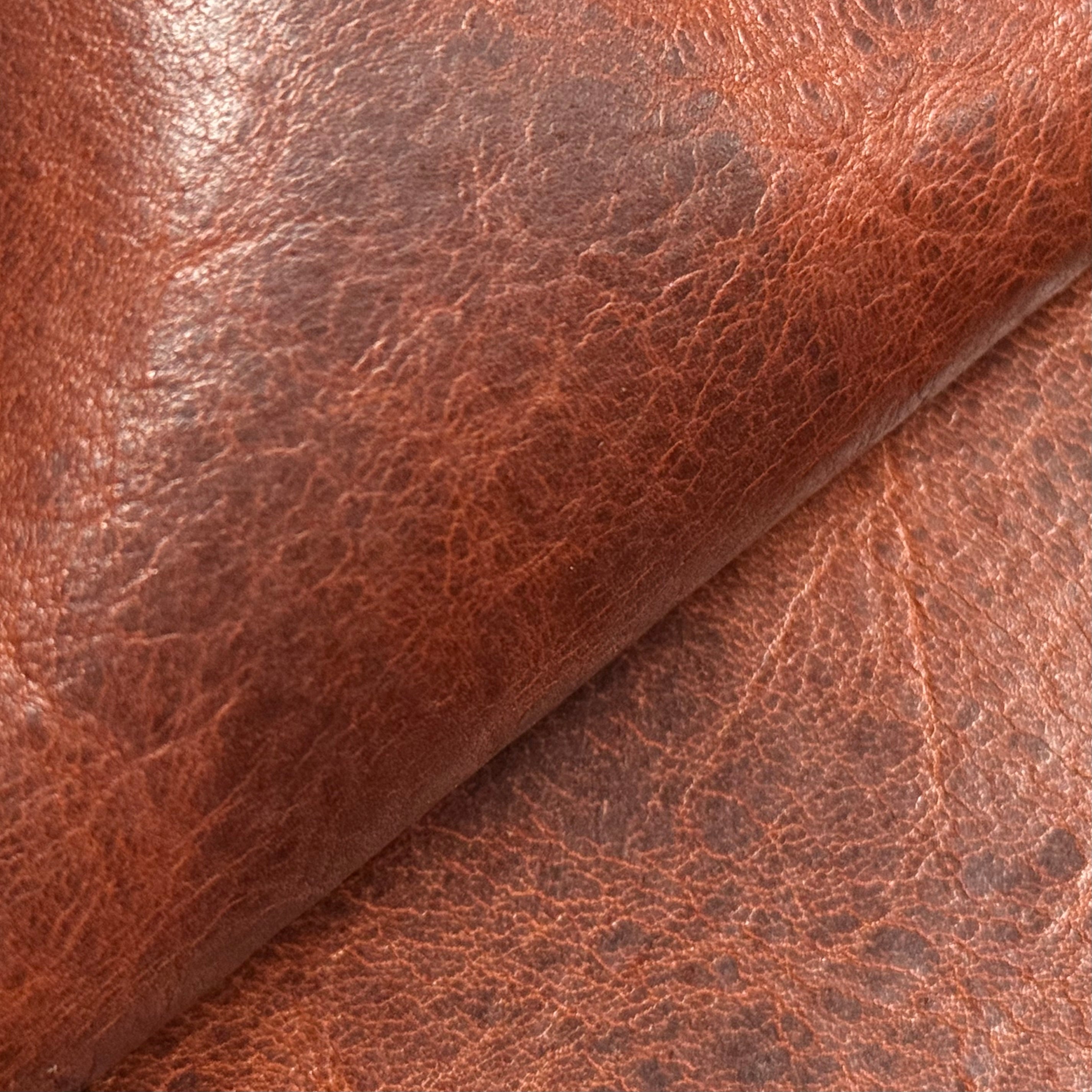 Distressed brown bison leather with irregular grain and worn colour
